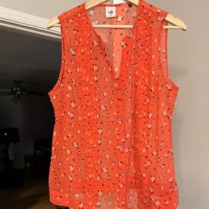 Salmon colored sleeveless blouse.
